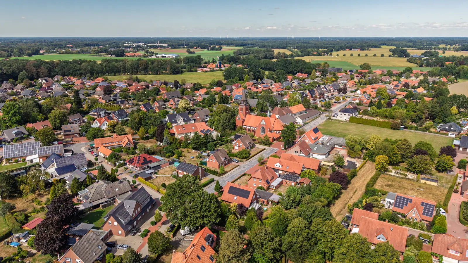 Drohnenaufnahme vom Ortskern Nortrup mit Kirche, Wohngebieten und Feldern im Süden des Artlands
